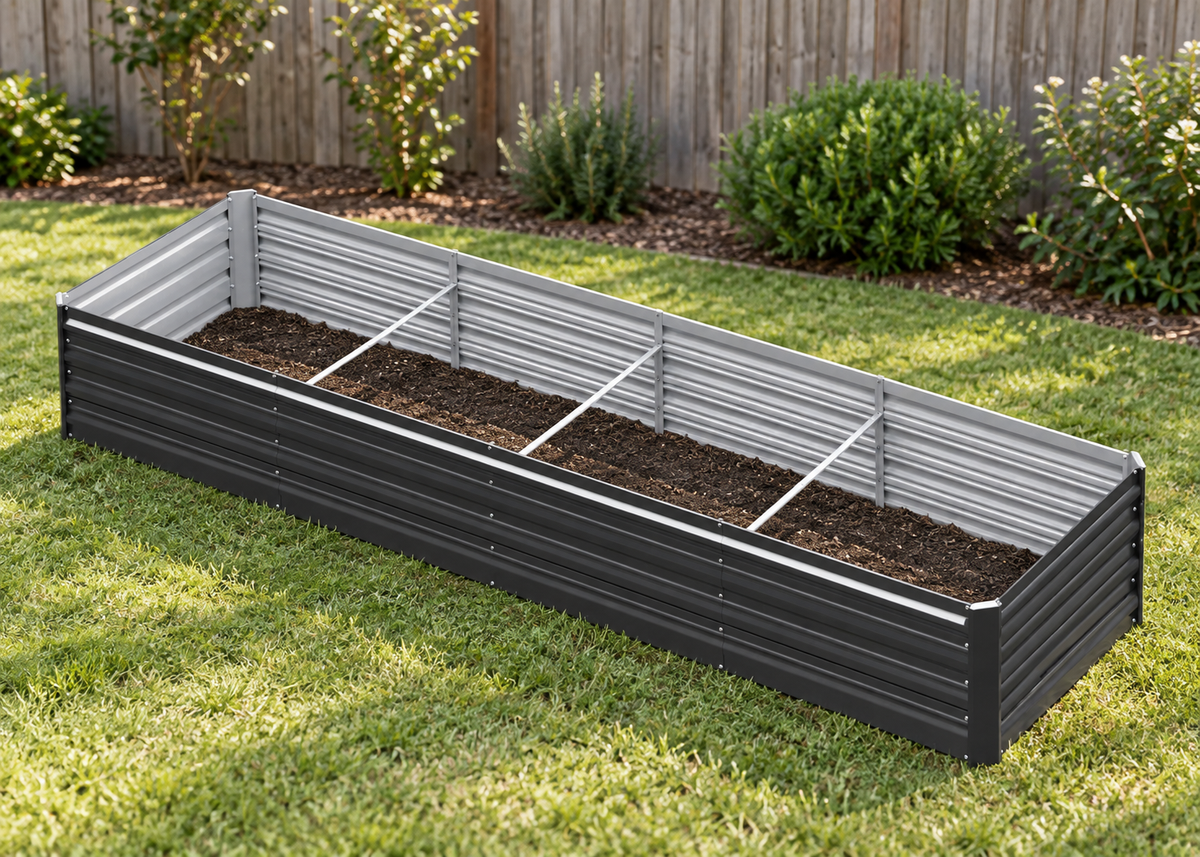 A rectangular raised garden bed with a dark charcoal-black corrugated metal exterior and light gray slatted sides, filled with soil and placed on a green lawn in front of a wooden fence.