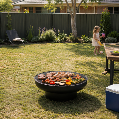 Outdoor setting with a fire pit grill on grass, child playing in the background