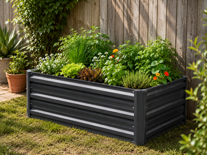 A rectangular raised garden bed with horizontal slats, filled with green plants and small orange flowers, set on grass in front of a wooden fence.