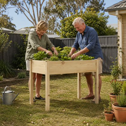 Two people tending to plants in a raised garden bed outdoors.