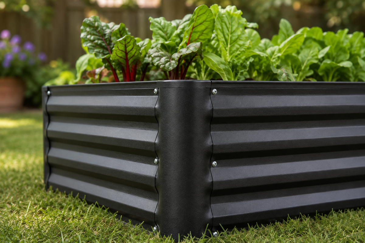 A black corrugated metal raised garden bed filled with leafy green vegetables, set on a green lawn in an outdoor garden setting.