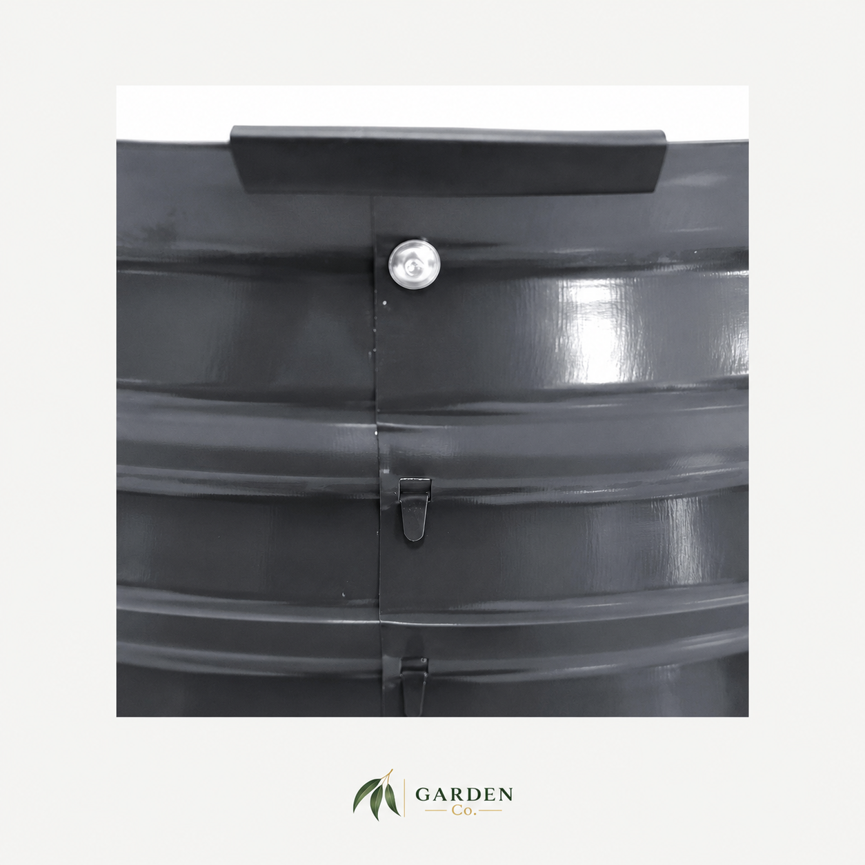 Close-up of a black corrugated plastic garden tub or planter with a central seam, a silver metal screw cap, and a black rubber guard, shown on a light gray background with a Garden Co logo at the bottom.