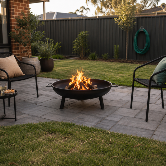 Black Steel Outdoor Fire Pit in a backyard with chairs and a hose in the background
