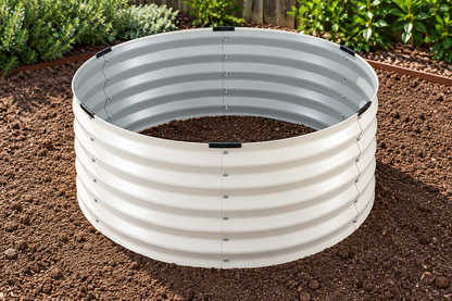 A circular corrugated metal raised garden bed filled with soil, shown outdoors in a garden bed with plants in the background.