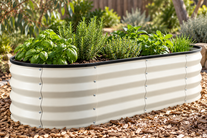 A rectangular raised garden bed with a corrugated metal exterior, filled with green herbs and plants, set on a bed of wood chips in an outdoor garden.